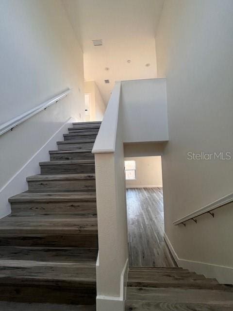 stairs with wood finished floors and baseboards