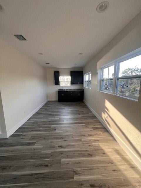 interior space featuring baseboards, visible vents, and wood finished floors