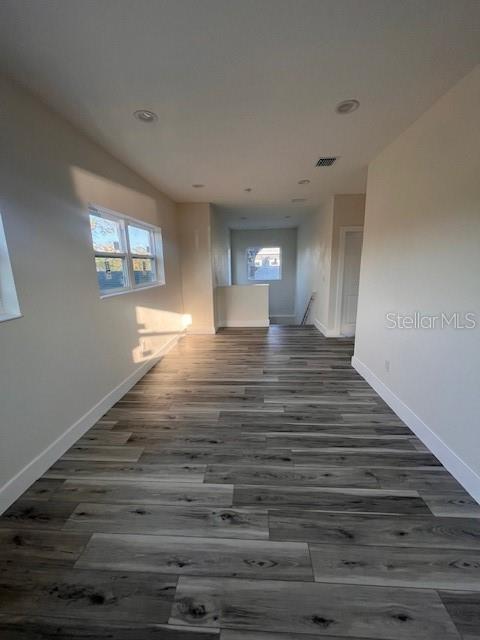 hall with baseboards, visible vents, wood finished floors, an upstairs landing, and recessed lighting