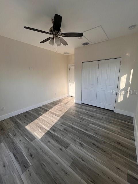 unfurnished bedroom with visible vents, baseboards, a ceiling fan, wood finished floors, and a closet