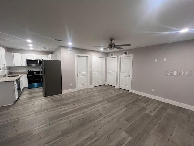 kitchen featuring stainless steel appliances, open floor plan, visible vents, and wood finished floors