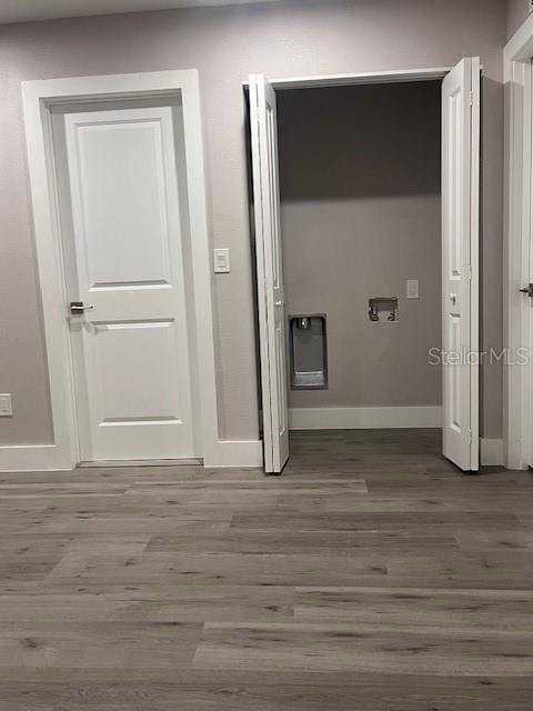 hallway with wood finished floors and baseboards