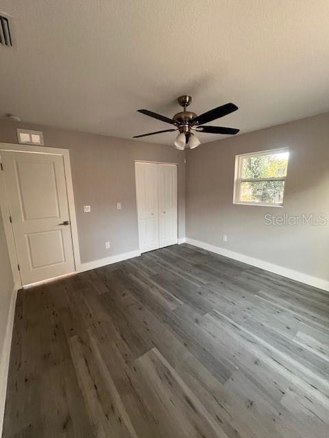 unfurnished bedroom with dark wood finished floors and baseboards