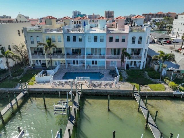 exterior space featuring a water view, a patio area, and a community pool