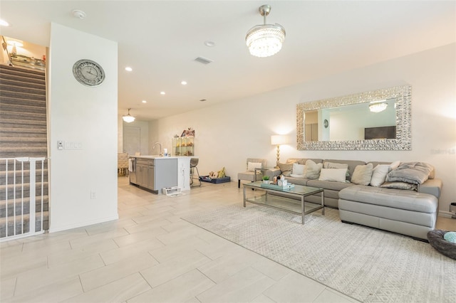 living room featuring recessed lighting, visible vents, baseboards, and stairs