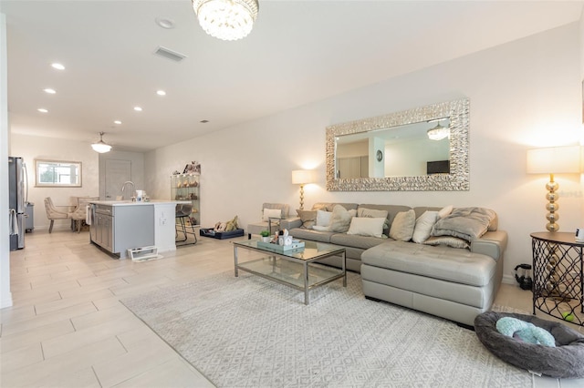 living area featuring baseboards, visible vents, and recessed lighting