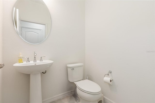 bathroom featuring baseboards and toilet