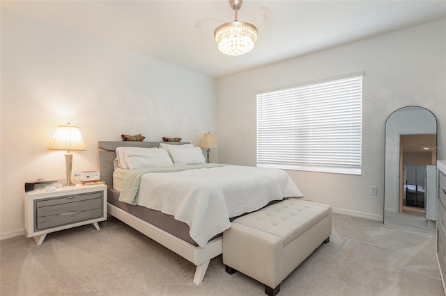 bedroom with baseboards, a notable chandelier, and light colored carpet