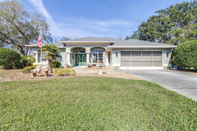 view of front of property featuring an attached garage, a shingled roof, concrete driveway, stucco siding, and a front yard