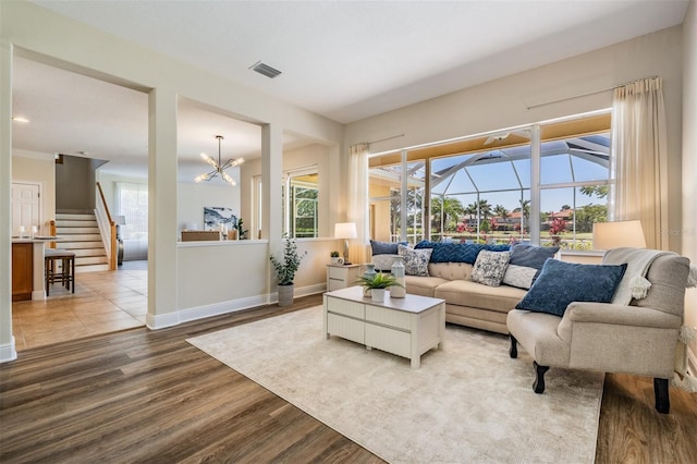 2665 Lakebreeze Ln N, Clearwater, FL 33759 - living area with wood finished floors, a chandelier, and stairs