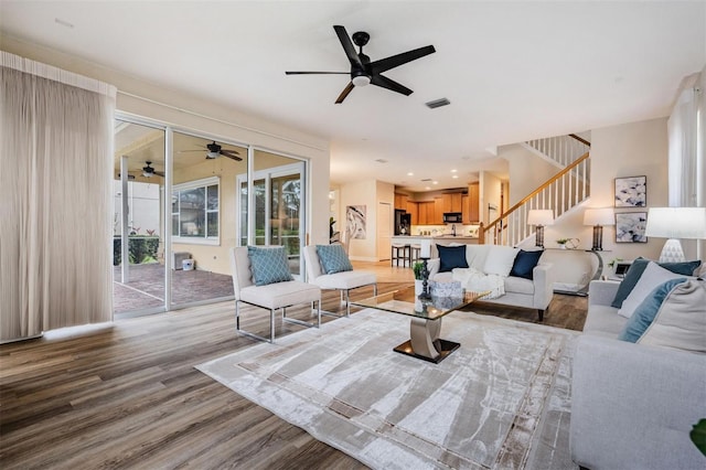 2665 Lakebreeze Ln N, Clearwater, FL 33759 - living area featuring a ceiling fan, wood finished floors, and stairway