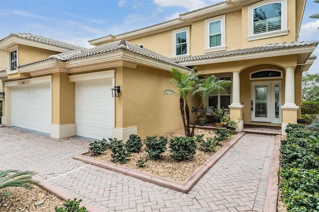 2665 Lakebreeze Ln N, Clearwater, FL 33759 - view of front facade with stucco siding, covered porch, decorative driveway, a garage, and a tile roof