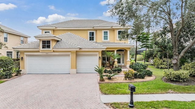 2665 Lakebreeze Ln N, Clearwater, FL 33759 - view of front of property featuring stucco siding, decorative driveway, a tiled roof, and a garage