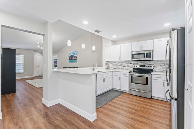 kitchen featuring light wood finished floors, stainless steel appliances, tasteful backsplash, visible vents, and white cabinetry