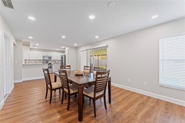 dining room with recessed lighting, visible vents, a textured ceiling, and light wood finished floors