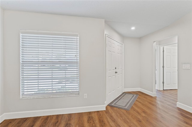 foyer featuring baseboards and wood finished floors