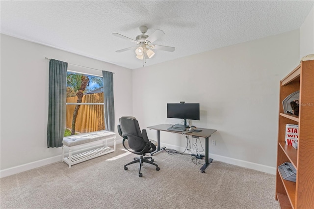 carpeted office space with a ceiling fan, baseboards, and a textured ceiling