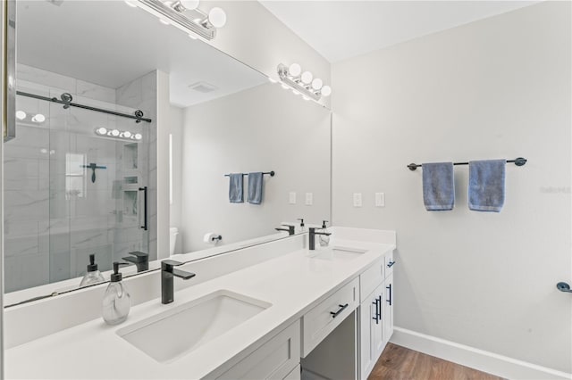 bathroom with toilet, a shower stall, baseboards, and a sink