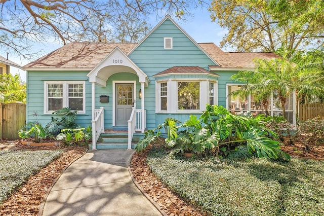 view of front of house featuring fence and roof with shingles