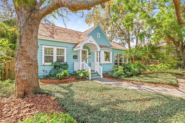 view of front of property featuring fence and roof with shingles