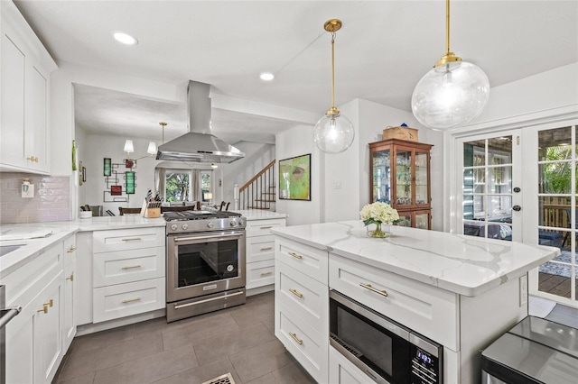 kitchen with decorative backsplash, a peninsula, island exhaust hood, stainless steel appliances, and white cabinetry