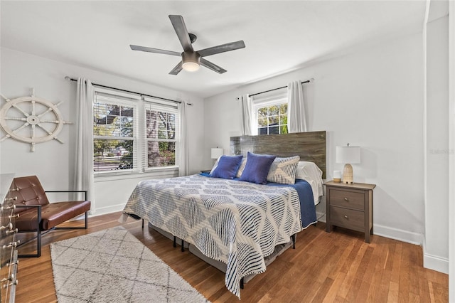 bedroom with a ceiling fan, baseboards, and wood finished floors