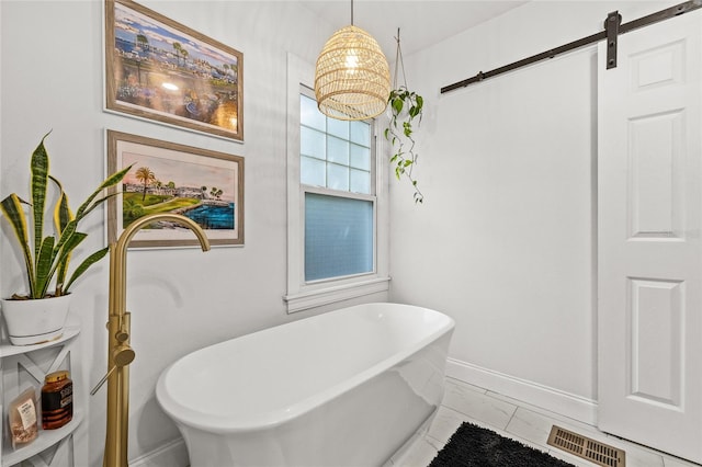 full bathroom featuring a freestanding tub, baseboards, and visible vents