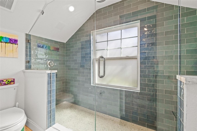 bathroom featuring lofted ceiling, visible vents, toilet, a walk in shower, and baseboards