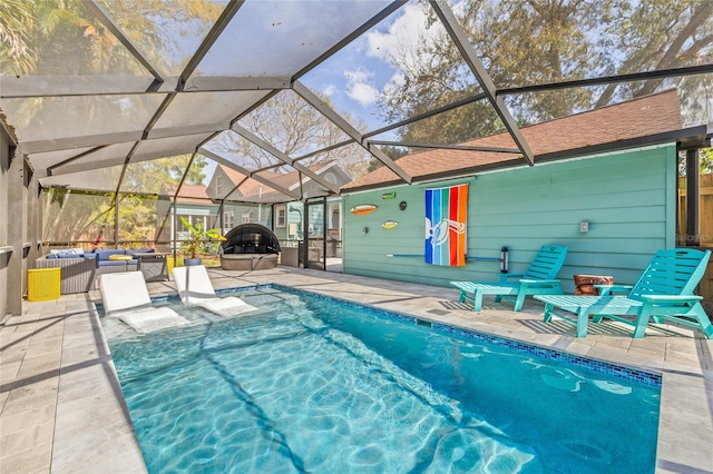 outdoor pool with glass enclosure, a patio area, and an outdoor living space