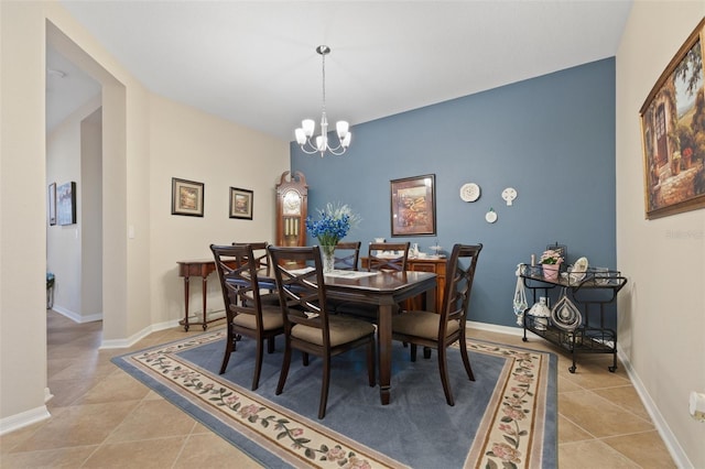 dining room featuring a notable chandelier, baseboards, and light tile patterned floors