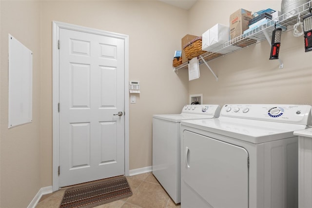 clothes washing area featuring laundry area, light tile patterned floors, baseboards, and washer and dryer