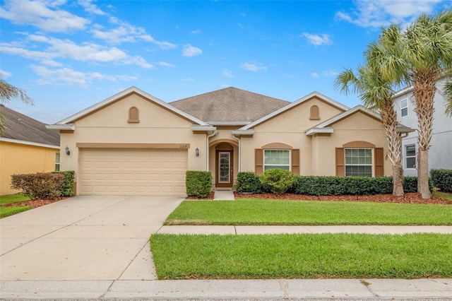 ranch-style house featuring a garage, concrete driveway, a front lawn, and stucco siding