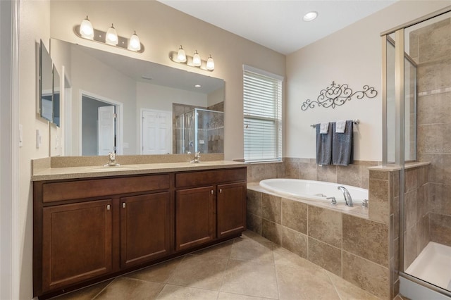 full bathroom with a sink, double vanity, tile patterned floors, a garden tub, and a stall shower
