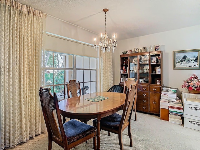 dining room with light carpet, a textured ceiling, and a notable chandelier