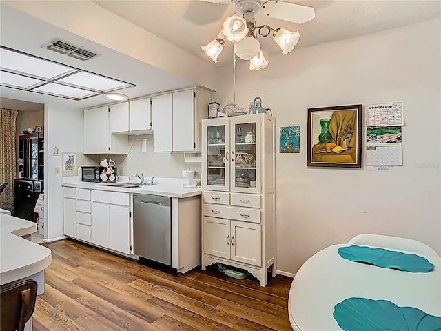 kitchen featuring visible vents, dishwasher, dark wood-style flooring, light countertops, and a sink