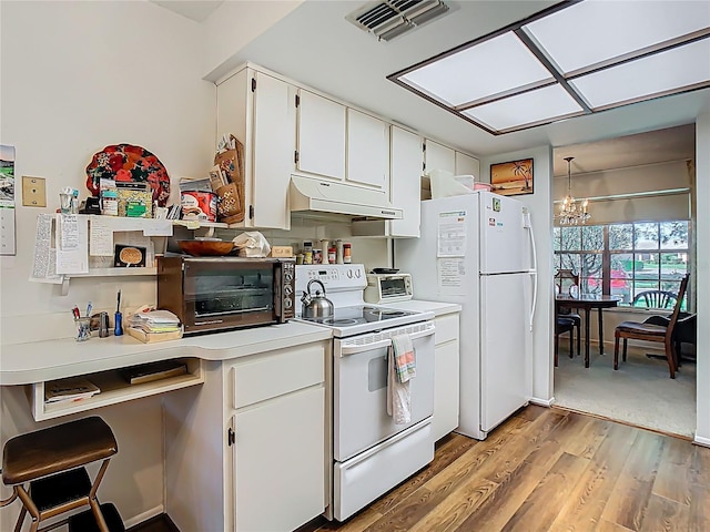 kitchen with a chandelier, under cabinet range hood, white appliances, visible vents, and light countertops