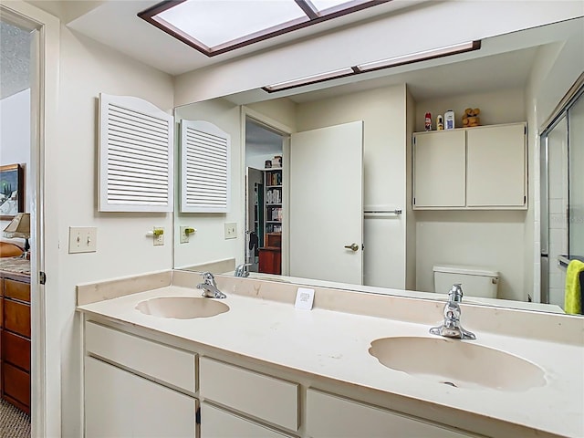 full bath featuring toilet, double vanity, and a sink