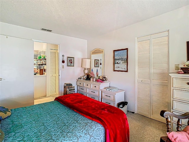 bedroom with a textured ceiling, visible vents, and light colored carpet