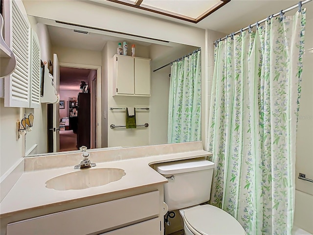 bathroom with curtained shower, vanity, and toilet