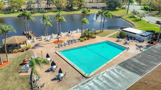 pool with a water view, a patio, and fence