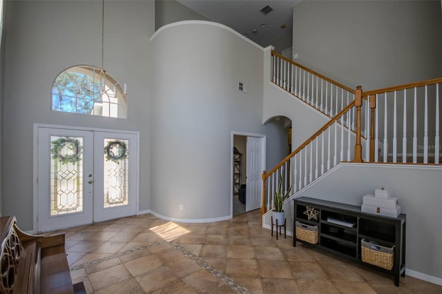 entryway with arched walkways, french doors, stairway, and baseboards