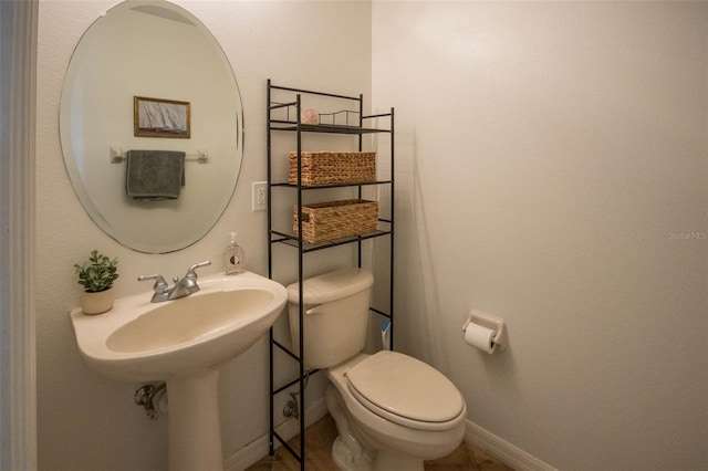 bathroom featuring baseboards and toilet