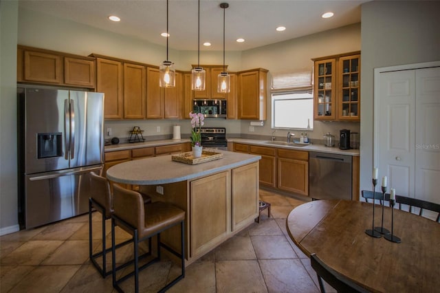 kitchen featuring recessed lighting, stainless steel appliances, a center island, brown cabinets, and glass insert cabinets