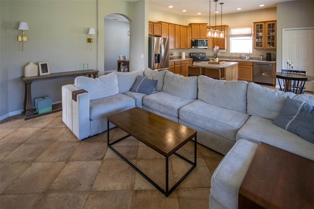 living room featuring arched walkways, baseboards, and recessed lighting