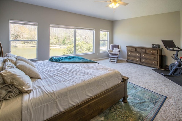 bedroom featuring a ceiling fan, light colored carpet, and baseboards