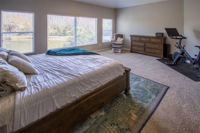 bedroom featuring light colored carpet and baseboards