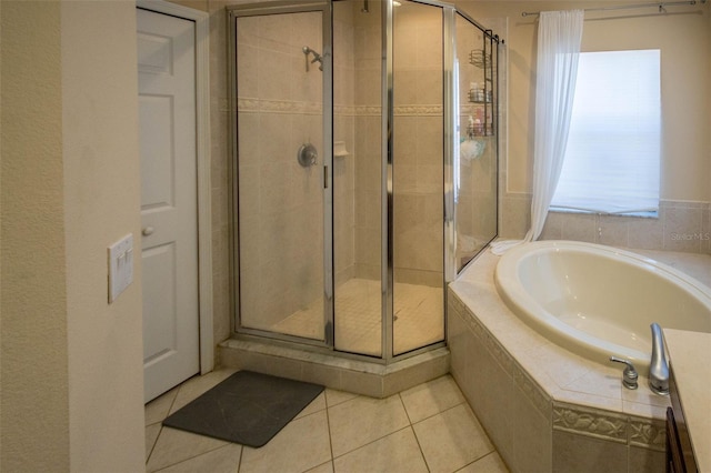 bathroom with a stall shower, tile patterned flooring, and a bath