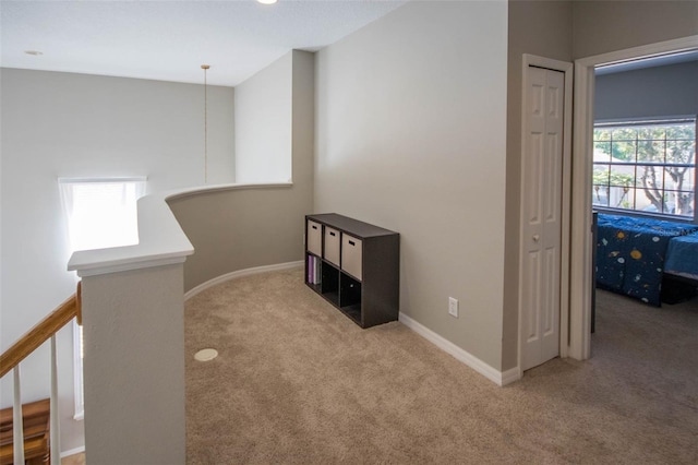 corridor with carpet flooring, an upstairs landing, and baseboards