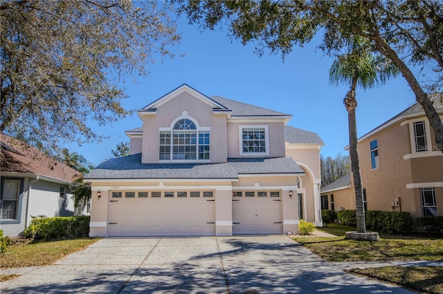 traditional home featuring a garage, driveway, roof with shingles, and stucco siding