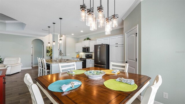 135 Cabana Way, Rotonda West, FL 33947 - dining room with arched walkways, crown molding, baseboards, dark wood-type flooring, and a chandelier